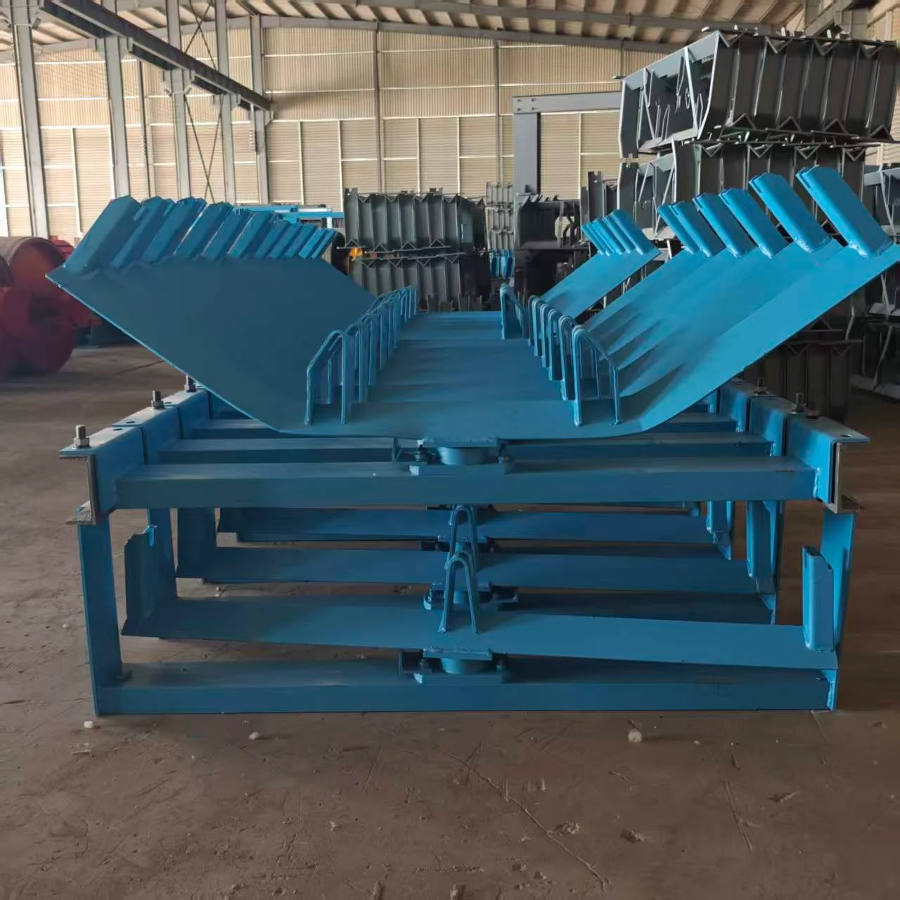 Front view of blue conveyor support frames in the workshop