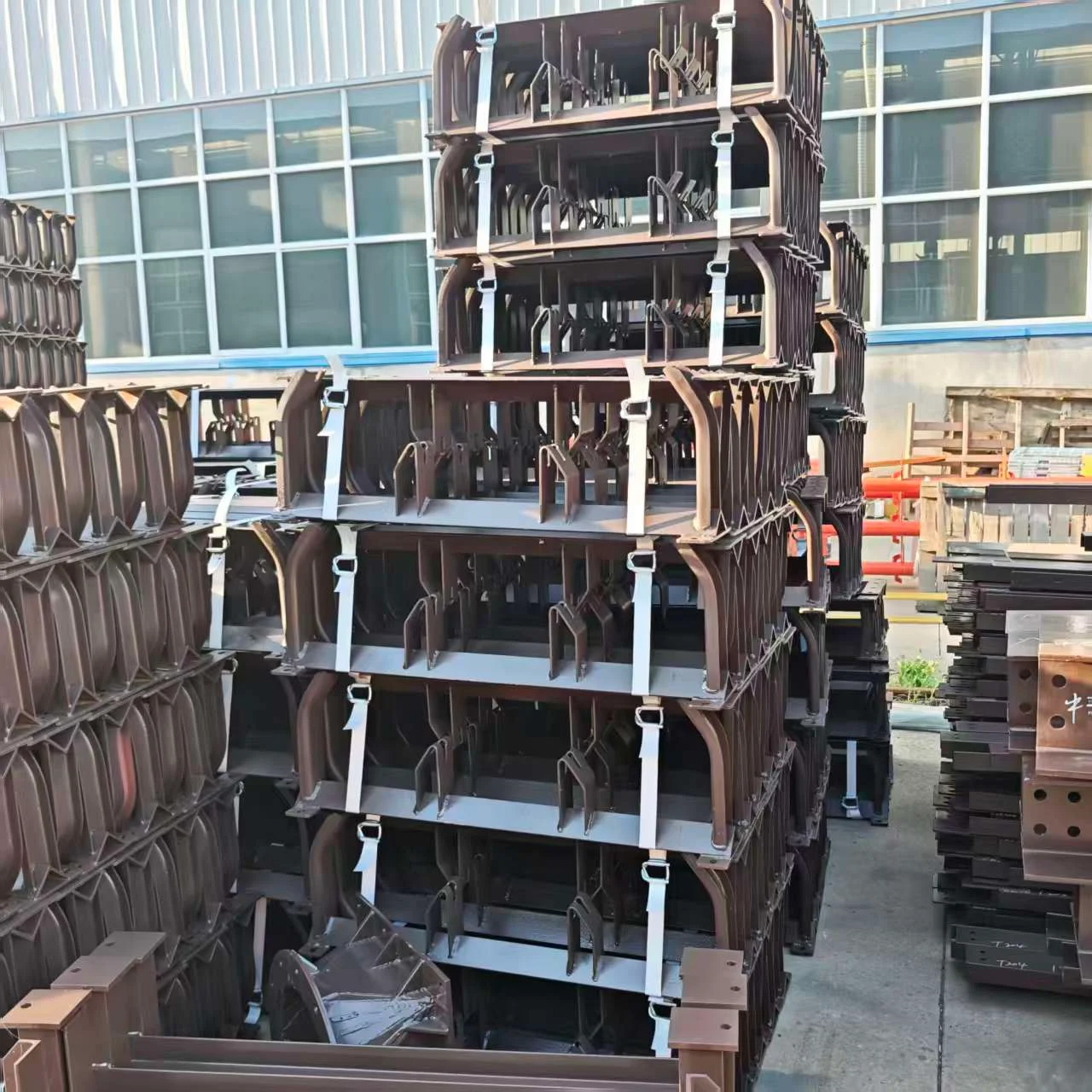 Stacked conveyor support frames outside the workshop